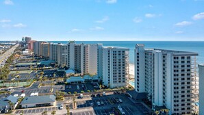 A high-rise hotel with multiple floors, a parking lot, and a view of the ocean. - Windward Pointe 1401-large Balcony Best Views (Orange Beach)