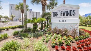 Une enseigne indiquant « TRADEWINDS », avec le numéro 24368, entourée de jardins aménagés et de palmiers.