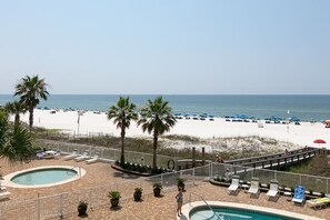 A pool area with lounge chairs and a view of the beach. - Windward Pointe 305 3rd Floor Beachfront Pool (Orange Beach)