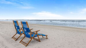 Two blue beach chairs on a sandy beach with the ocean in the background. - Island Winds West 774- Walk to Hangout Beachfront (Gulf Shores)