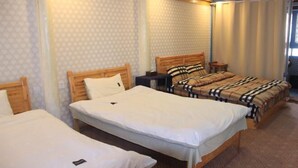 Une chambre d’hôtel avec deux lits simples, une tête de lit en bois, une table de chevet et une moquette à motifs.