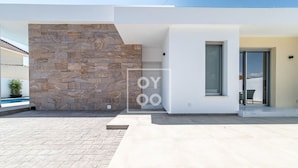 Un edificio moderno con fachada de piedra y puerta de entrada de vidrio.
