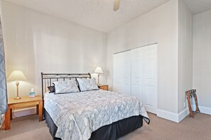 A bedroom with a bed, bedside tables, a wardrobe, and a shoe rack.