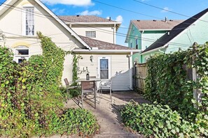 A small house with a patio, a table, and chairs.