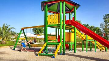 A playground with a slide, swings, and climbing structures.
