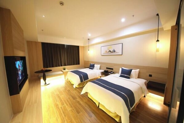A hotel room with two beds, a flat-screen TV, a desk, and a large window. - Yancheng Gangbo Peninsula Hotel (Yancheng)
