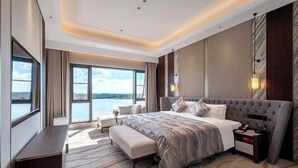 Una habitación de hotel moderna con una cama grande, un escritorio y vistas al agua.
