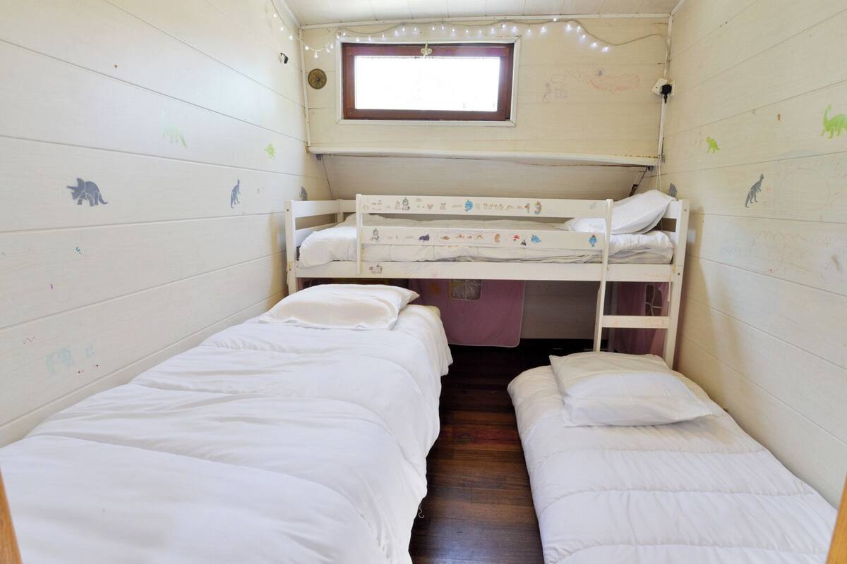 Een knus, gelijkvloers huisje met stapelbedden en een raam.