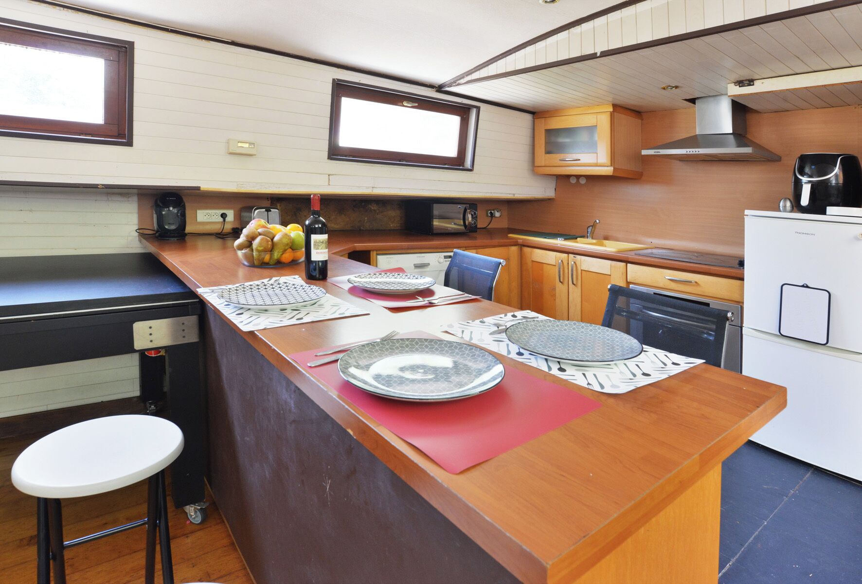 A compact kitchen with a central island, a microwave, a stove, and a refrigerator.