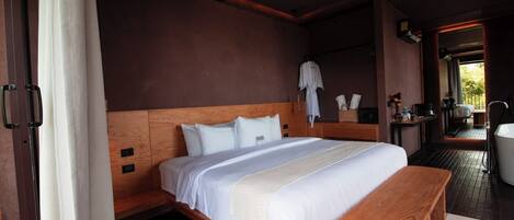 A spacious bedroom with a large bed, wooden headboard, and a bench.