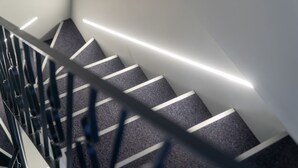 A modern staircase with a metal railing and a carpeted floor. - giardini inn arte (Giardini Naxos)