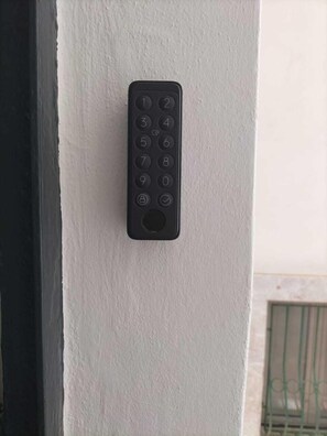 A black wall-mounted keypad on a white wall. - giardini inn arte (Giardini Naxos)
