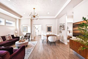 Un salón amplio con un sofá grande, un reposapiés y un comedor.