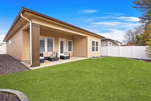 A single-story house with a covered porch, a well-maintained lawn, and a white fence. - 2 Adjacent Modern Homes • Sleep 16 • Near Top Shopping, Dining & Entertainment (Meridian)