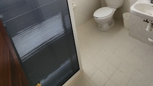 Une salle de bain avec des toilettes, un lavabo et une fenêtre.
