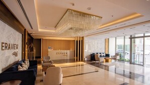 Eine moderne Hotelhalle mit einer Rezeption, einer Sitzecke und großen Fenstern.
