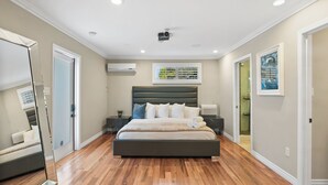 A bedroom with a large bed, a ceiling projector, and a window with blinds. - DREAM HOUSE IN PASADENA (Pasadena)
