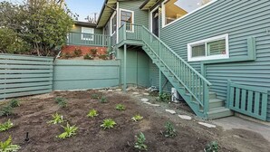 A house with a green exterior, a small garden with young plants, and a staircase leading to a second floor. - DREAM HOUSE IN PASADENA (Pasadena)