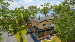 A modern two-story house with a glass-enclosed patio, a hot tub, and a view of a lake. - La Vue O-Lac Magog (Sherbrooke)