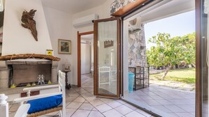 Amplia sala de estar con chimenea, una mesa de comedor con sillas y un ventanal corredero que da a un patio exterior.