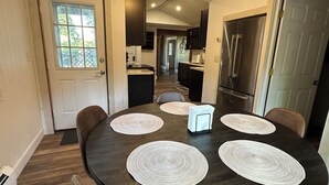 A dining area with a round table, four placemats, and chairs. - Spacious ski chalet with pool table & mountain views (Rutland)