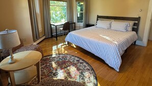 A bedroom with a bed, a desk, a chair, a lamp, a ceiling fan, and a window with curtains. - Spacious ski chalet with pool table & mountain views (Rutland)