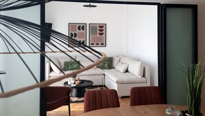 Ein modernes Wohnzimmer mit einem Holzesstisch, einem weißen Sofa und einer Pendelleuchte.