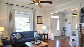 A living room with a blue sofa, wooden coffee table, and a ceiling fan.