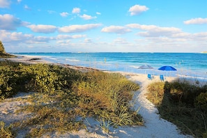 Na praia, espreguiçadeiras, toalhas de praia 