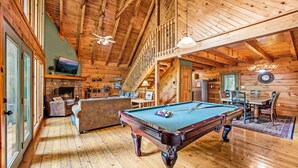 A spacious room with a pool table, comfortable seating, and a fireplace. - Spring With A View! Hot Tub, Theater, Pool Table (Gatlinburg)