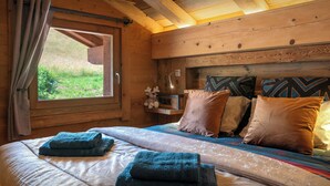 A wooden cabin room with a bed, pillows, a window, and a teddy bear. - Chalet K1027 - mountain stay 14p spa and Mont Blanc views - OVO Network (Cordon)
