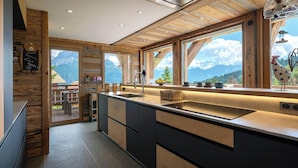 A modern kitchen with wooden accents, a large window offering a mountain view, and a welcoming sign. - Chalet K1027 - mountain stay 14p spa and Mont Blanc views - OVO Network (Cordon)