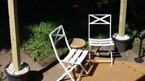 A wooden pergola with string lights, two white chairs, and a woven basket on a concrete patio. - 4bed studio basement! 5min->downtownKC (Kansas City)