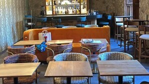A cozy restaurant with a bar area, wooden furniture, and a stone wall. - Fishers House Hotel San Miguel (San Miguel de Allende)