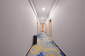 A long, narrow hallway with a patterned carpet, light-colored walls, and a trash bin. - Shangyou Express Hotel (Dachang)
