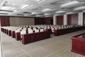 A conference room with rows of chairs and a long table, a podium, and a carpeted floor. - Shangyou Express Hotel (Dachang)