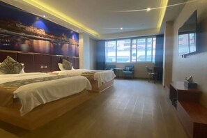 Une chambre d’hôtel avec deux lits, une grande fenêtre, un téléviseur à écran plat et un bureau.