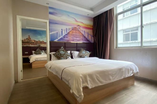 Un dormitorio con cama, un cuadro en la pared, una ventana y una puerta que da a otra habitación.