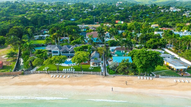 An aerial view of a coastal resort with beachfront properties, a swimming pool, and lush greenery. - 🏝️ Sleep to Caribbean Waves Pool | Beach + Pool + AC • Ocho Rio (Ocho Rios)