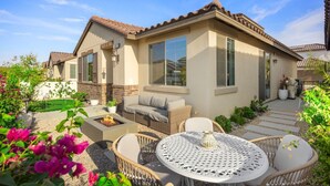 A residential property with a patio area, outdoor seating, and a well-maintained garden.