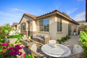 A residential property with a patio area, outdoor seating, and a well-maintained garden.