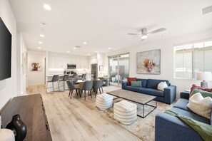 A modern living room with a sofa, ottomans, and a coffee table. - Golf Lover's Haven: Putting Green & Pool Access (La Quinta)
