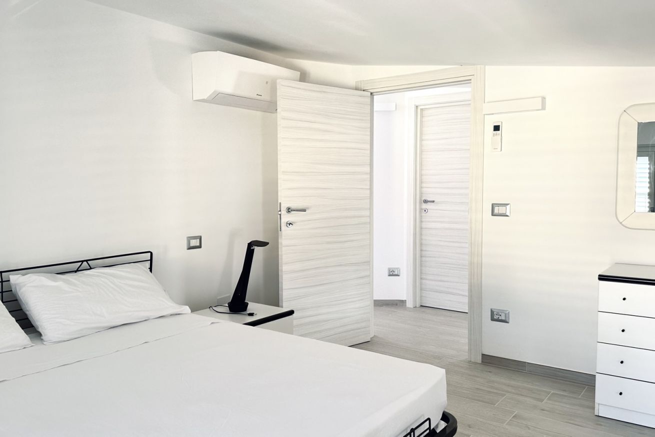 Una camera da letto con un letto, un comodino e un armadio.