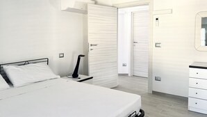 Un dormitori amb un llit, una taula de nit i un armari.