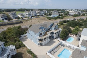 A large two-story house with a balcony and a swimming pool.