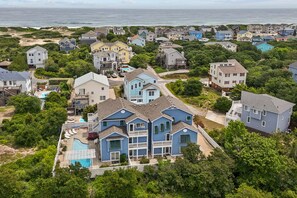 A residential area with houses, a swimming pool, and a view of the ocean.