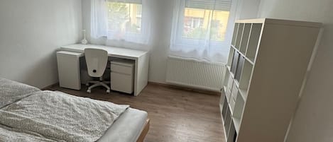 Une chambre à coucher avec un lit, un bureau et une armoire.