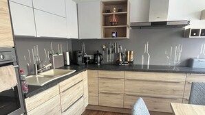A modern kitchen with wooden cabinets, a black countertop, and a built-in wine rack.