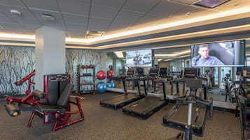 A gym with treadmills, weight machines, and exercise balls.