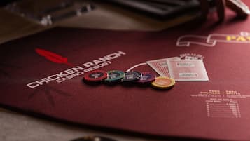 A red table with a logo for Chicken Ranch Casino Resort, poker chips, and a menu.
